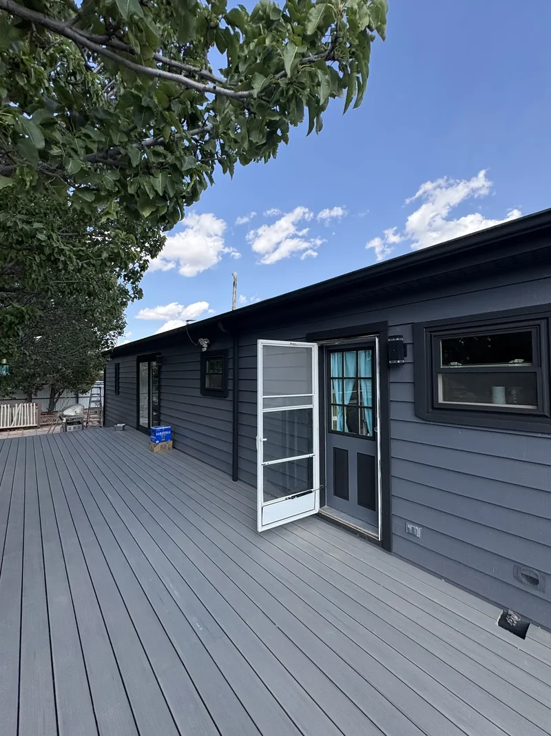 Restored deck boards and railing beside a shade tree