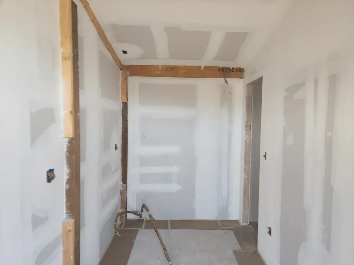 Hallway drywall hung and finished to a flat, paint-ready surface
