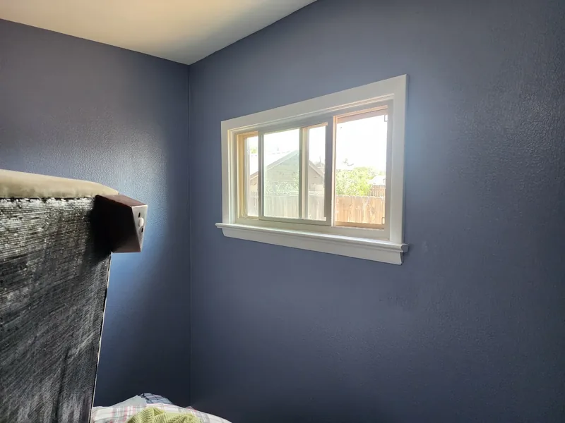 Bedroom with a deep navy accent wall and crisp white trim