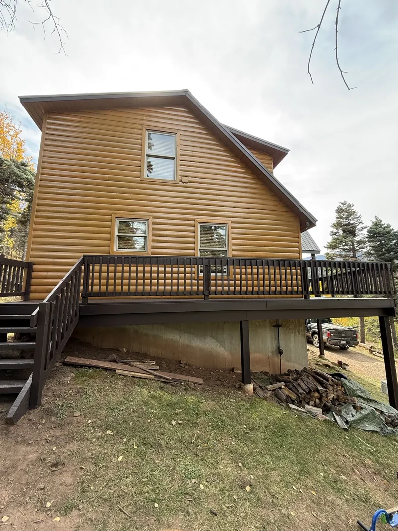 Two-story log home with a freshly stained wraparound deck