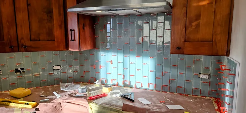 Kitchen tile backsplash set around outlets under the cabinets