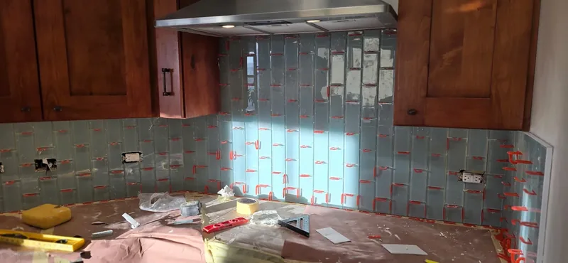 Full kitchen backsplash running under the upper cabinets